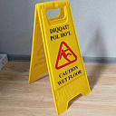 Знак «Осторожно мокрый пол» (на узбекском и английском языках)